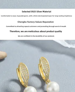 Vue macro de boucles d'oreilles en argent S925 avec perles blanches et détails pavés dorés