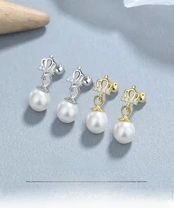 Close-up of crown shaped 925 silver pearl earrings with sparkling cubic zirconia