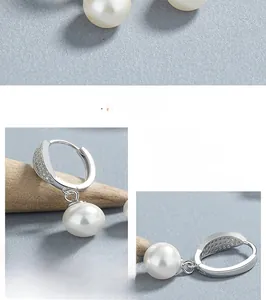 Gros plan sur les boucles d'oreilles goutte en argent 925 avec perles blanches et zircones