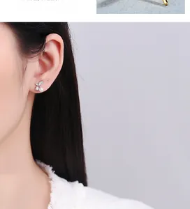 Detailed close-up of cherry-shaped silver stud earring with white pearl on model