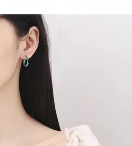 Dettaglio orecchini Mobius in argento 925 con finitura in smalto verde smeraldo su modella
