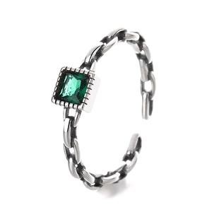 925 silver chain ring with emerald green stone on white background from a front angle