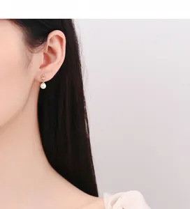 Detail of 925 silver gold crown pearl earring worn on a model, showing elegant texture