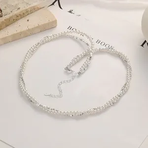 Detailed macro of hand-woven pearl and rhinestone choker with silver clasp and chain