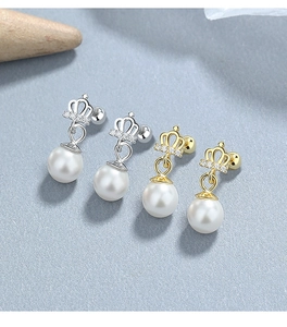 Detailed macro view of 925 silver and gold crown pearl stud earrings with sparkling stones