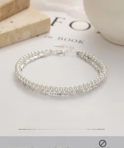 Detail view of double-layer silver bead and white pearl bracelet with lobster clasp