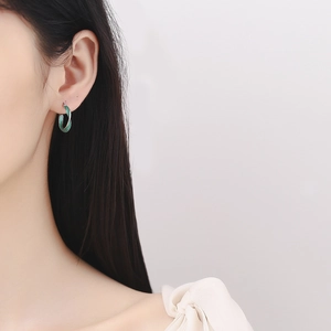 Orecchini Mobius in argento 925 con smalto verde mostrati lateralmente sull'orecchio