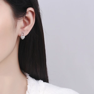 Orecchini a cuore in argento 925 con pavé di zirconi indossati da una modella