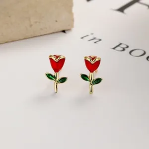 Detailed close-up of red and green tulip enamel stud earrings with gold plating