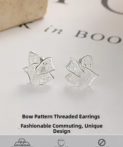 Macro shot of 925 sterling silver bow earrings with hollow woven texture and screw backings