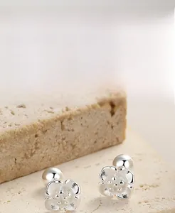 Macro shot of S925 sterling silver cherry blossom studs with matte flower texture