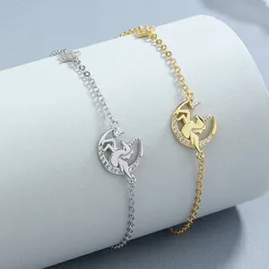 Close-up of 925 silver and 18K gold unicorn moon pendant bracelets on a white display