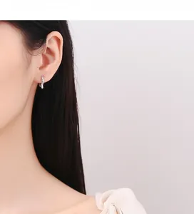 Detailed view of twisted 925 sterling silver hoop earrings with sparkling zircon stones