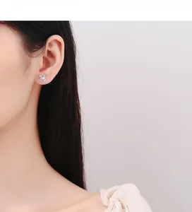 Detail of 925 sterling silver bow knot earrings worn by model in a soft pink setting