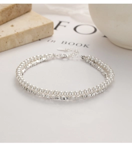 Detail of double-layer silver bead and pearl bracelet with lobster clasp and extender chain