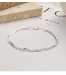 Dettaglio di un bracciale minimalista a tre strati in argento con maglia a serpente
