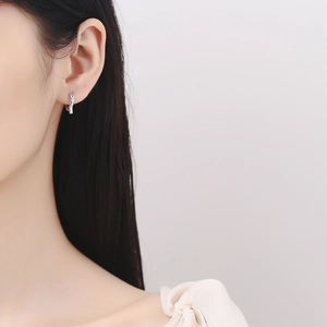 Elegant 925 sterling silver twisted hoop earrings with diamond accents worn by a model