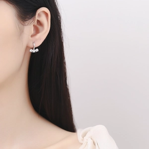 Eleganza di orecchini a cerchio in argento 925 con tre zirconi lucenti su una modella