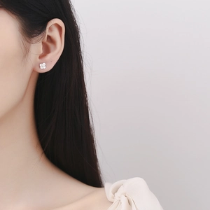 Elegant 925 sterling silver cherry blossom stud earring worn by a model in a minimalist style