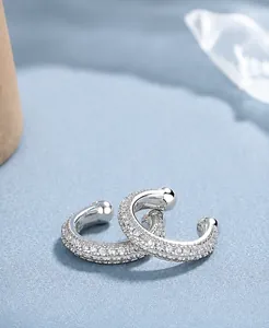 Dettaglio di orecchini a clip C in argento S925 con pavé di cristalli di zirconi cubici