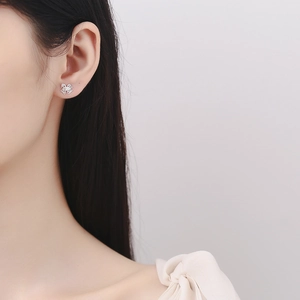 925 sterling silver hollow bow earrings for women worn by a model in soft light