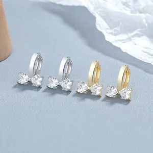 Détail de boucles d'oreilles nœuds argent et or avec cristaux de zircon étincelants