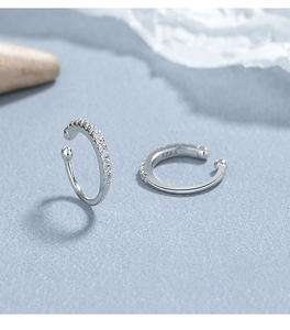 Dettaglio macro di orecchini a C in argento 925 con zirconi incastonati a pavé