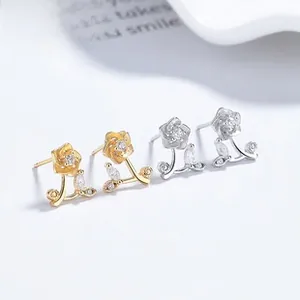 Close-up of sunflower stud earrings with cubic zirconia in gold and silver finishes
