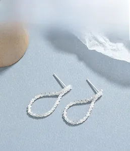 Macro detail of S925 sterling silver stud earrings with irregular hammered texture