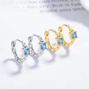Détail du zircon bleu carré et du motif de chaîne sur les boucles d'oreilles créoles