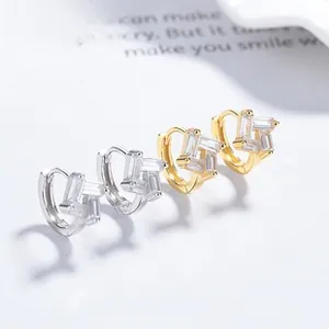 Détail de boucles d'oreilles carrées géométriques avec zircons en finition or et argent