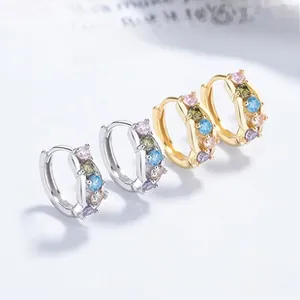 Macro shot of colorful zircon stones set in silver and gold plated hoop earrings