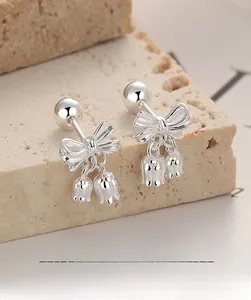 Gros plan de boucles d'oreilles muguet en argent 925 avec nœud et fermoir à vis à boule