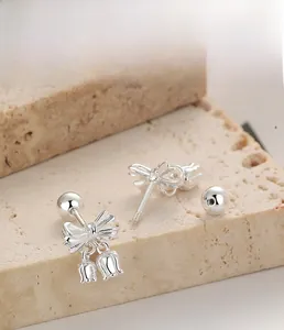 Gros plan détaillé des boucles d'oreilles muguet en argent S925 sur support en pierre