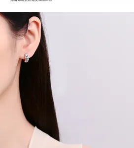 Macro shot of 925 silver hoop earrings with multi-colored gemstones worn on ear
