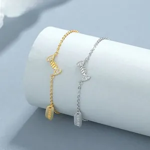 Close-up of zircon helix bracelet with a LUCKY metal tag in gold and silver finish