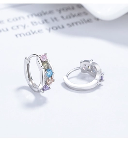 Macro detail of 925 silver hoop earrings with five colorful gradient zircons and S925 stamp