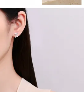 Gros plan macro sur boucle d'oreille nœud en argent S925 avec goutte de muguet