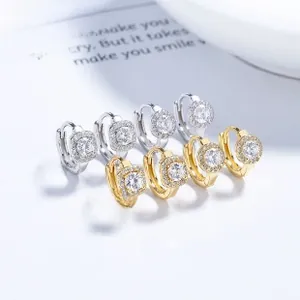 Macro detail of geometric silver earrings with cubic zirconia in gold and silver plating