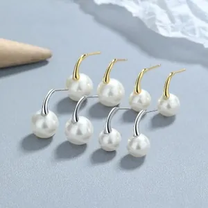 Detail view of 925 silver pearl earring set in gold and silver finishes on textured base