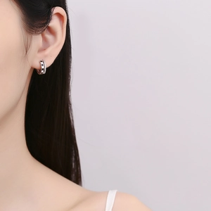 Boucles d'oreilles doubles anneaux damier en argent 925 avec zircons portées par mannequin