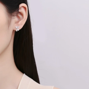 Élégantes boucles d'oreilles nœud muguet en argent S925 portées par un modèle