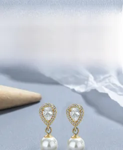 Macro detail of S925 silver teardrop earrings with zircon and round white pearl drop