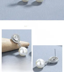 Macro detail of 925 sterling silver teardrop cubic zirconia and pearl drop earrings