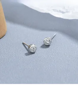 Dettaglio macro di orecchini a lobo in argento 925 con zirconi a castone tondo