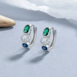 Vue macro des créoles en argent S925 avec pierres tricolores émeraude, zircon et saphir