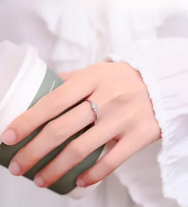 Detail of 925 silver rose ring with white enamel and a tiny crystal on model's hand