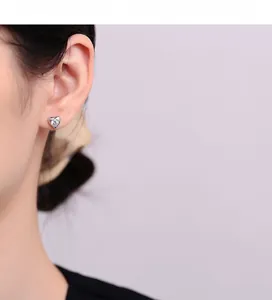 Detailed view of heart-shaped S925 silver stud earrings with zircon stones on an ear
