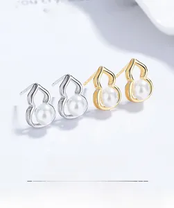 Detailed macro view of S925 sterling silver and gold gourd-shaped pearl stud earrings