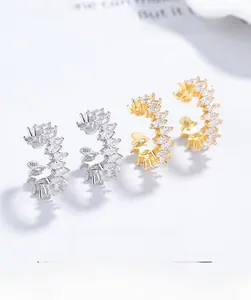 Gros plan sur des bagues d'oreilles en argent 925 avec zircons en argent et doré
